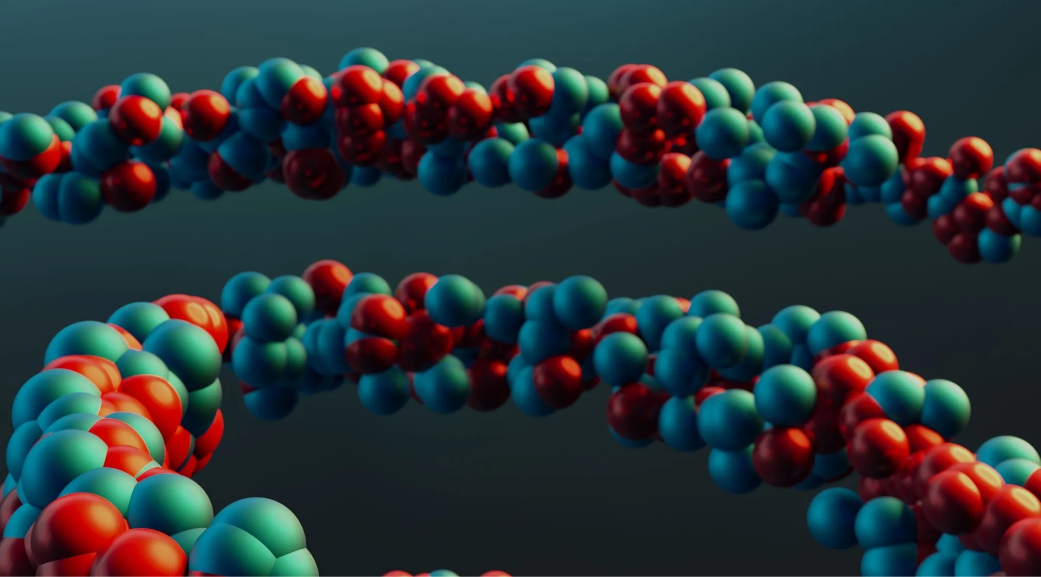 Abstract image of red and teal spheres forming two helical chains, representing elements in organic compounds.