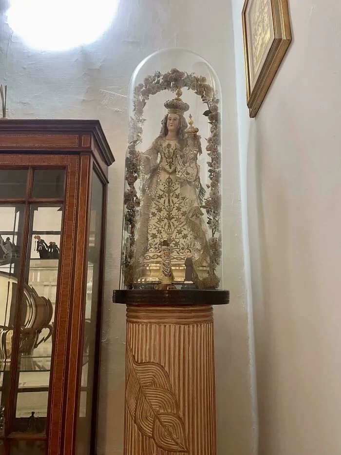 An ornate religious statue under a glass dome, included in unhinged real estate listings.