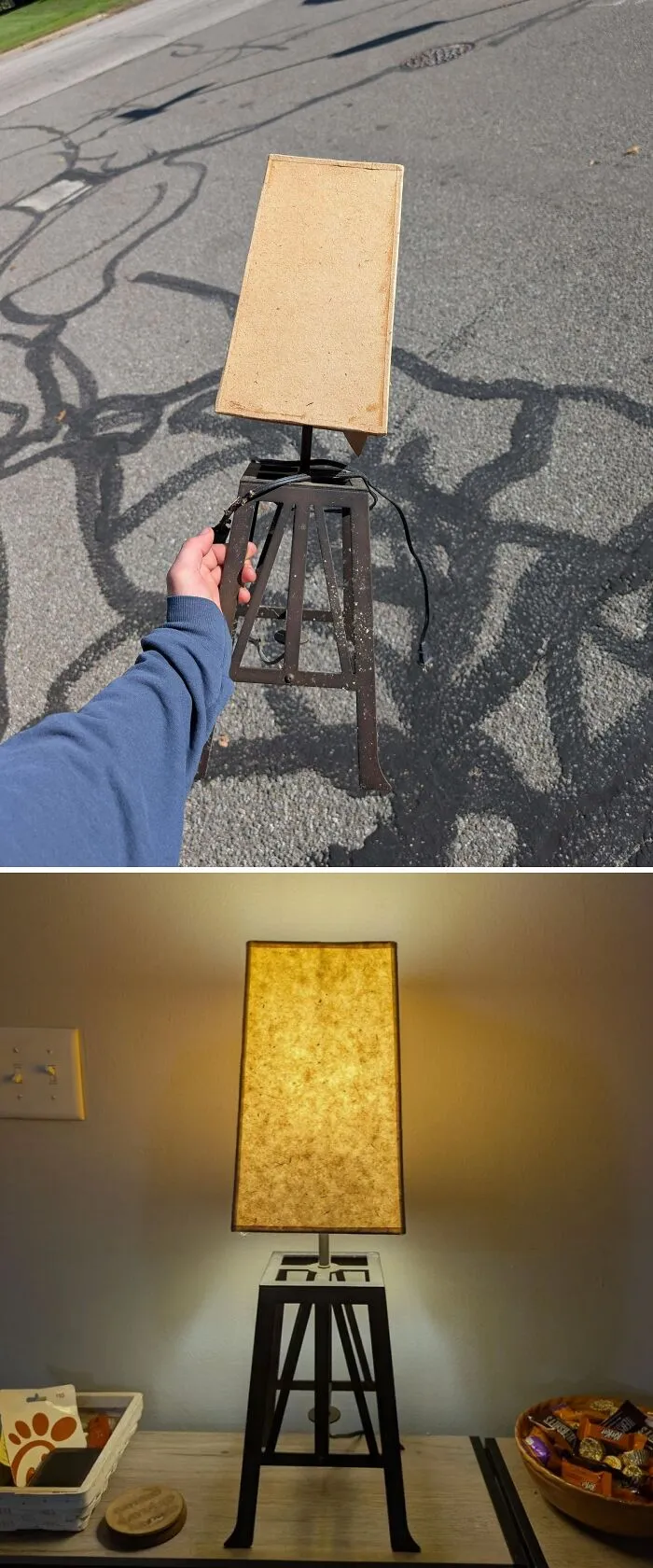 A person holding a lamp base found while dumpster diving, and the lamp lit up on a desk.