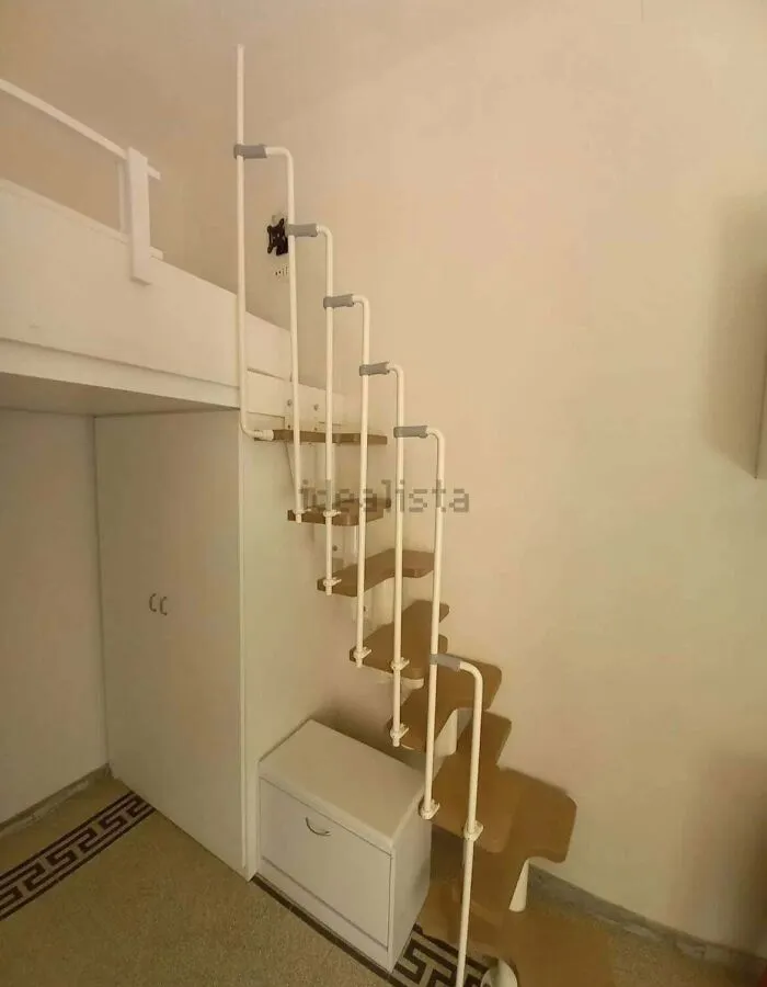 A steep, zigzagging ladder-style staircase leading to a loft, an unhinged real estate listing feature.