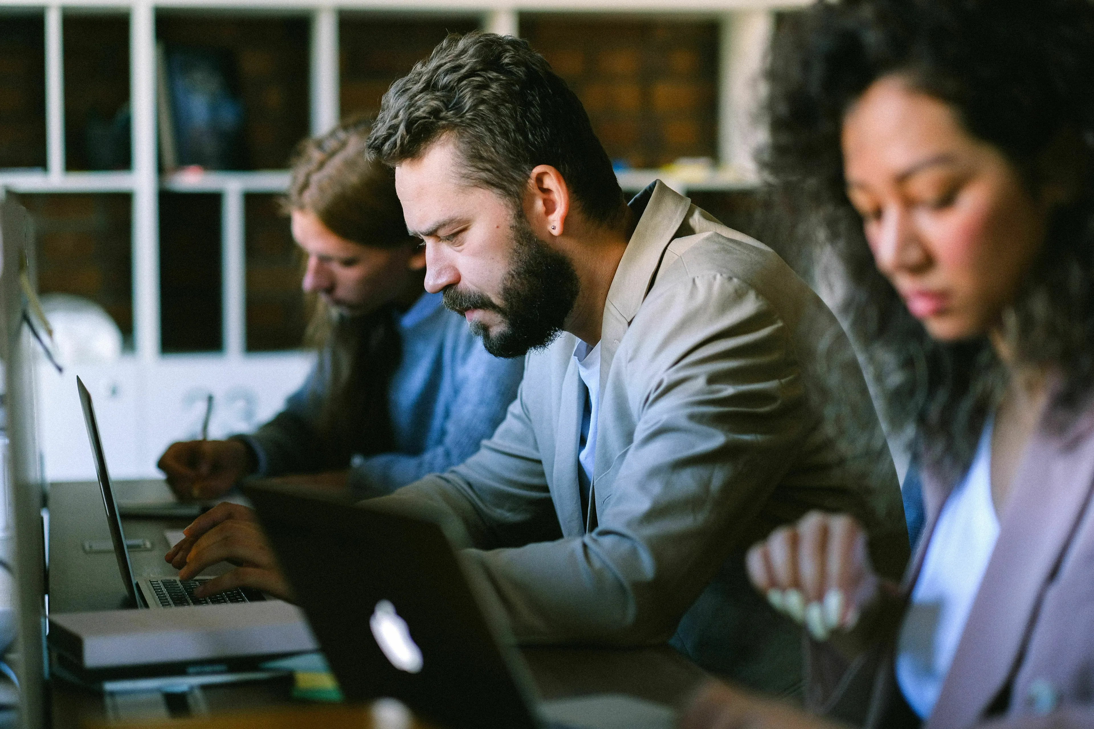 People working on laptops in an office, showcasing loneliness and relationship with own company.