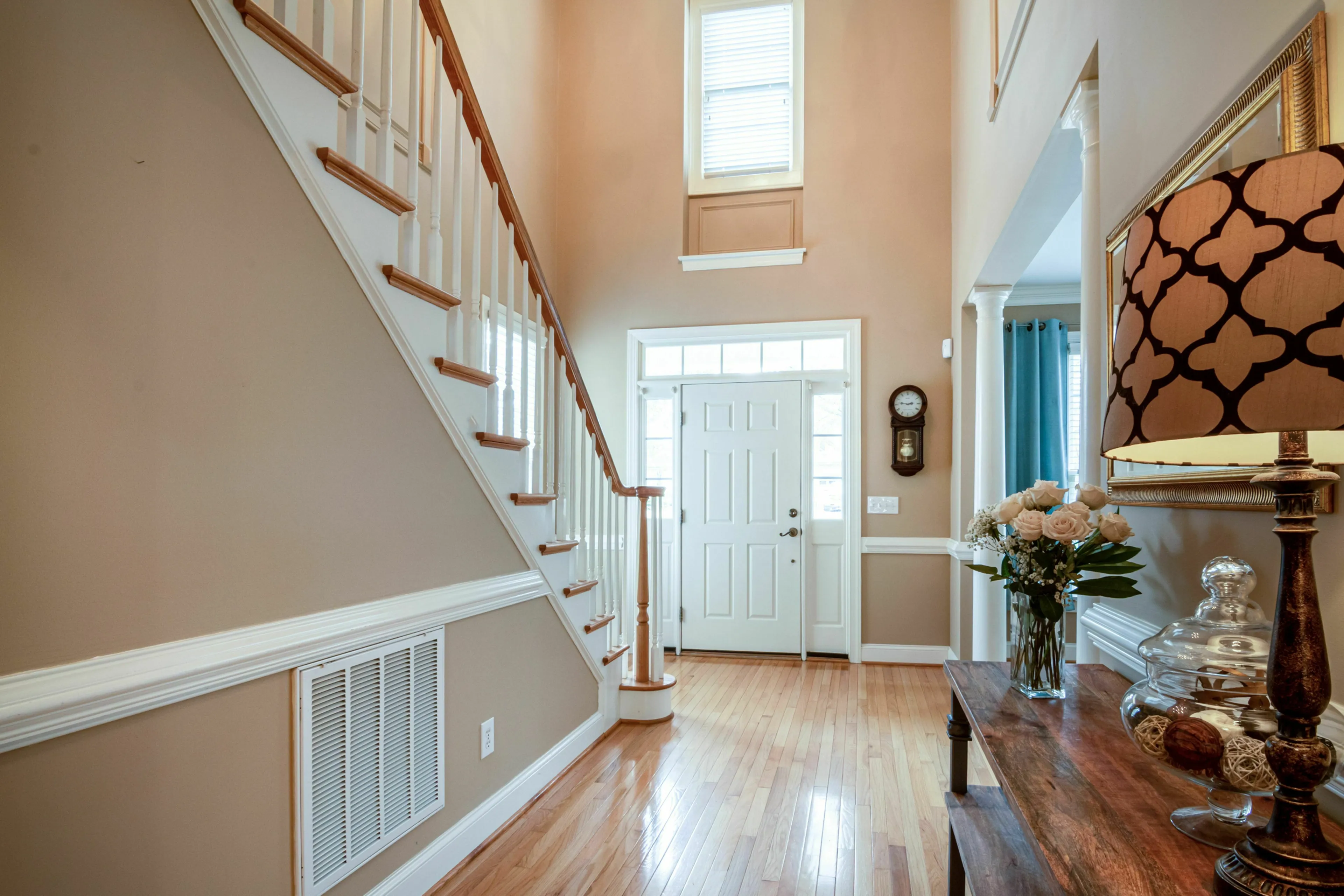 An empty house entryway with stairs and a front door, depicting the feeling of walking into an empty home and handling loneliness.