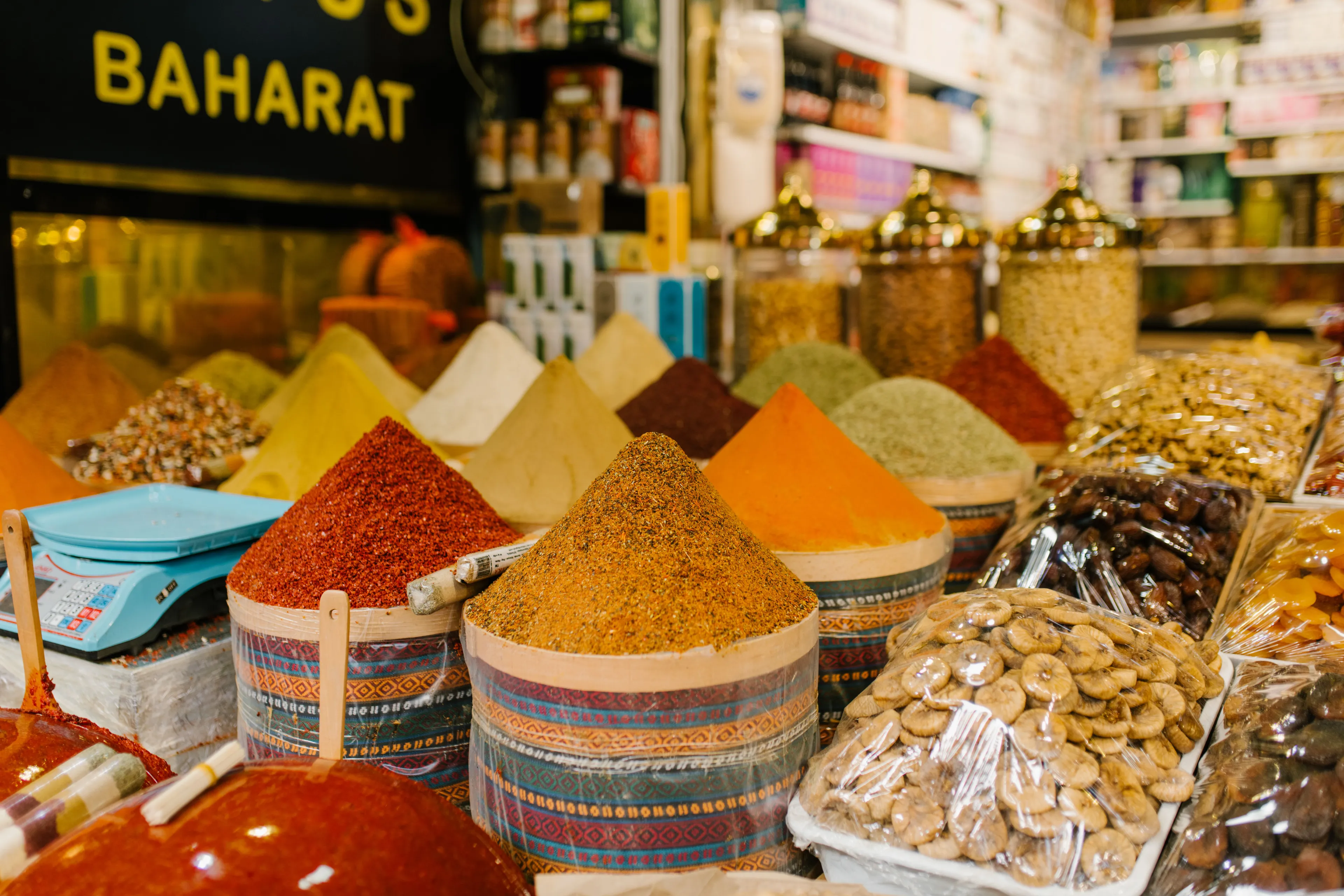 Colorful mounds of spices and dried fruits displayed at a market stall, showcasing the ideal job of a spice trader.