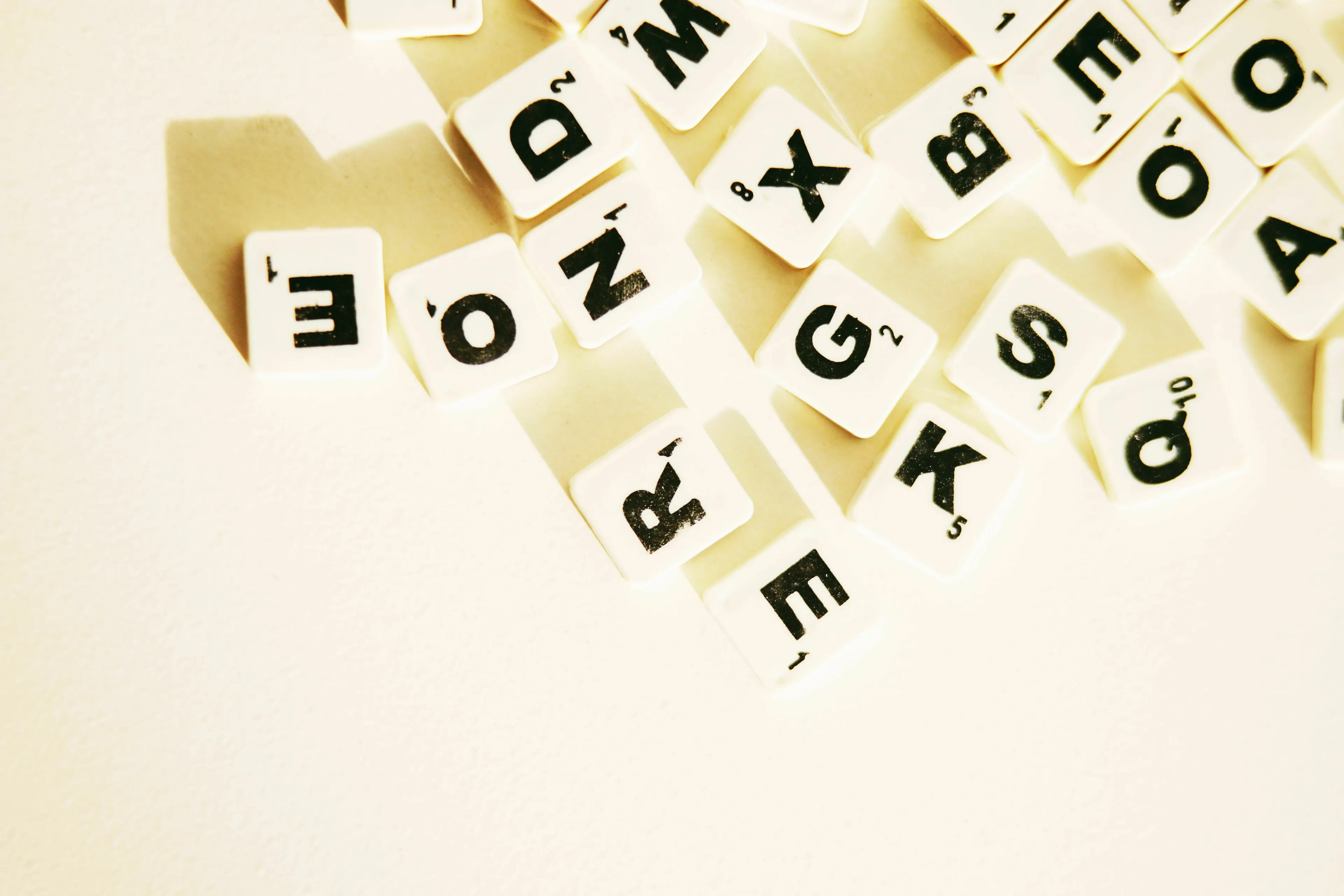 Scrabble-like letter tiles scattered, representing a word formed from first letters, for a Pub Trivia Quiz.