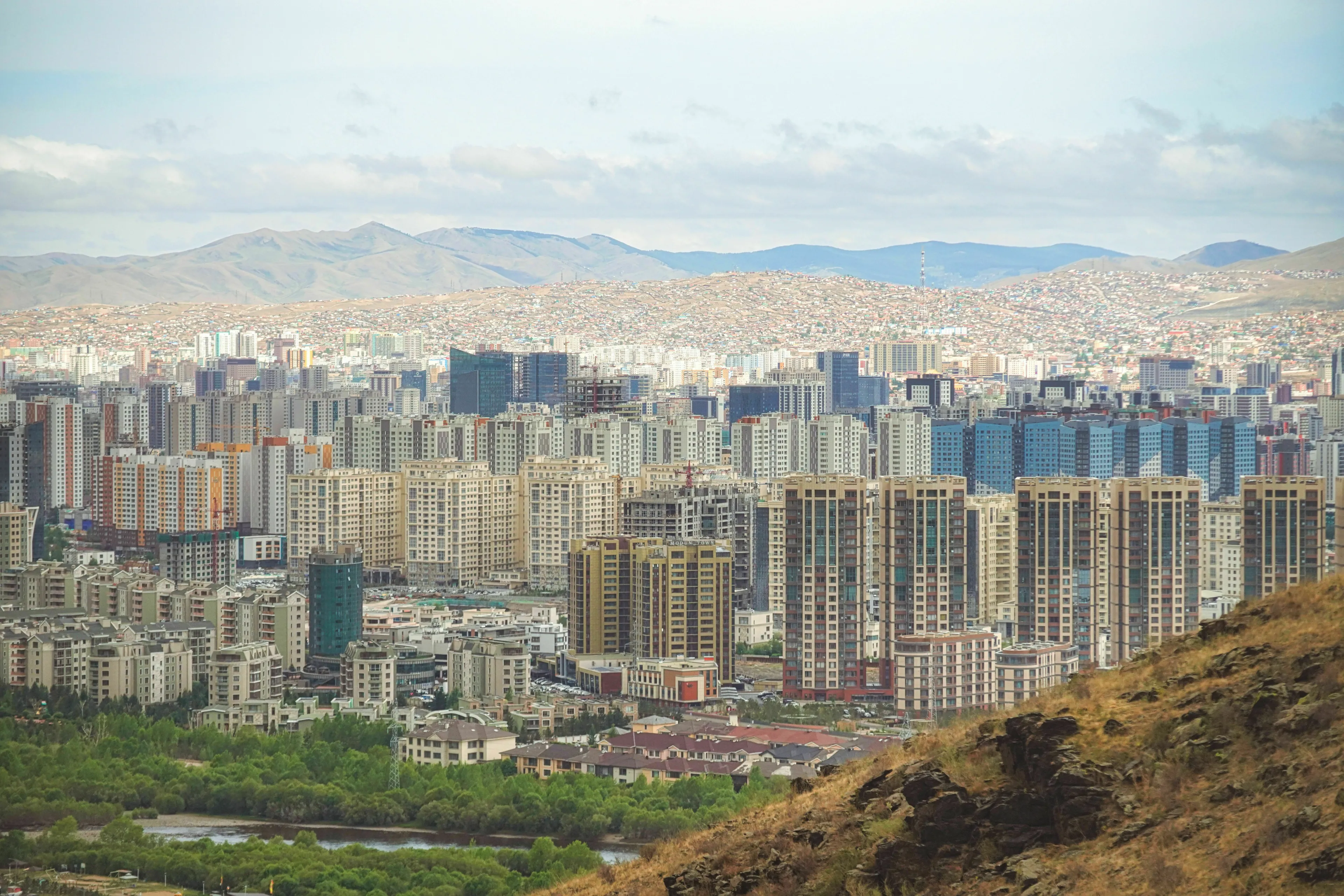 Pub Trivia Quiz: Ulaanbaatar, the capital city of Mongolia, with urban sprawl and mountains under a cloudy sky.