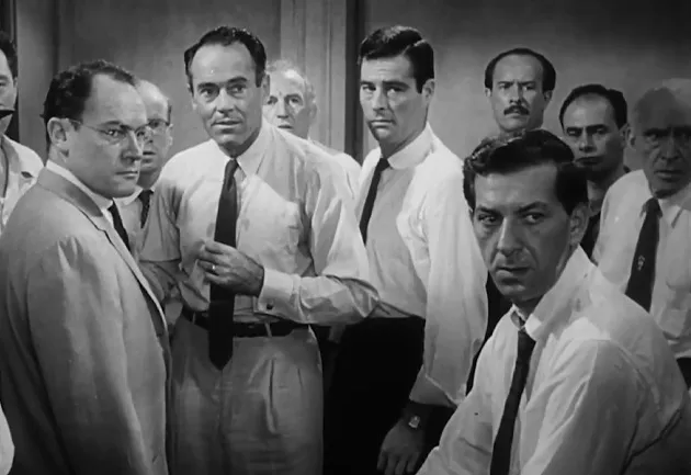 A group of 12 Angry Men in a courtroom, engaged in a discussion.