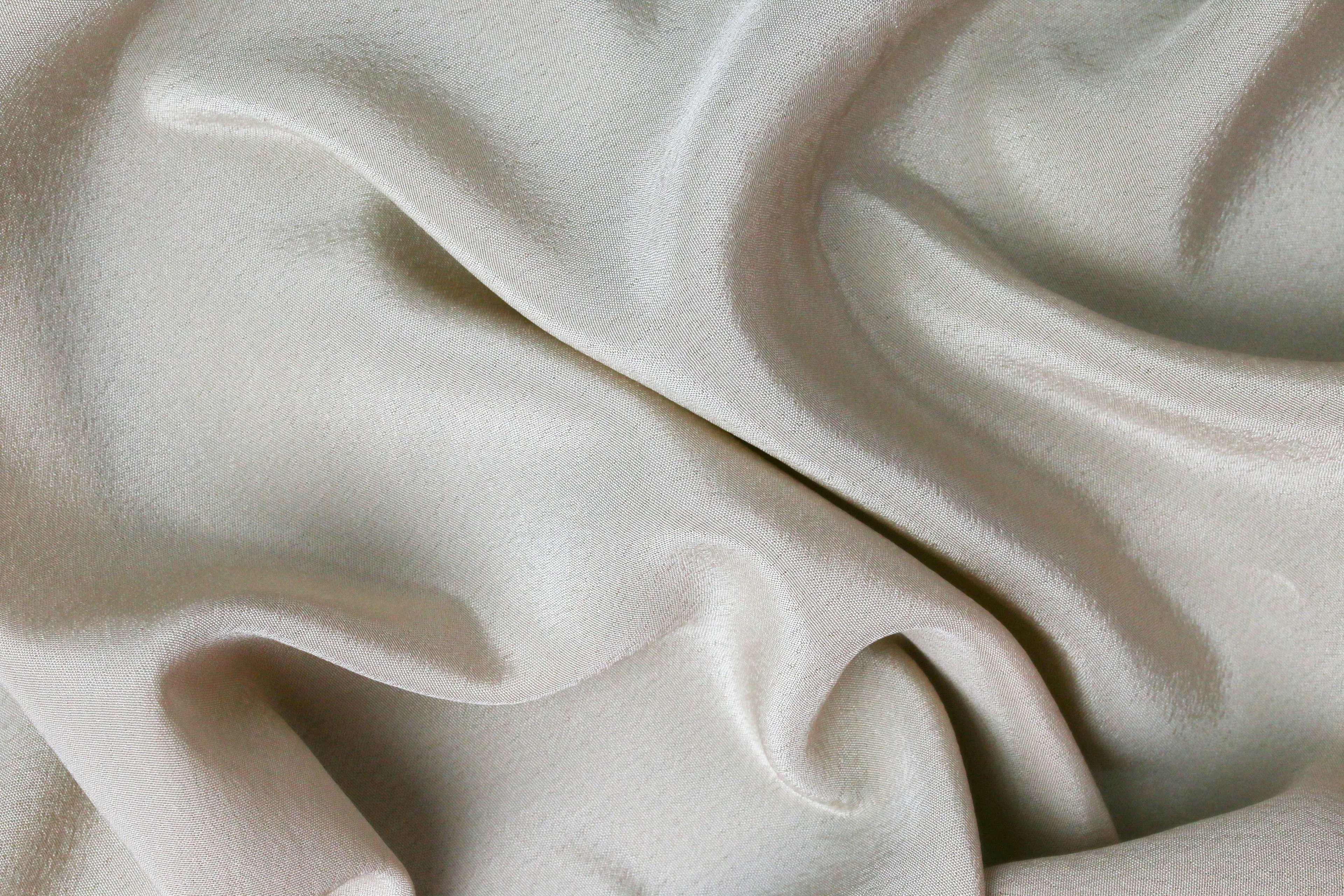 A close-up of a soft, flowing silk material with gentle folds, perfect for a material selection.