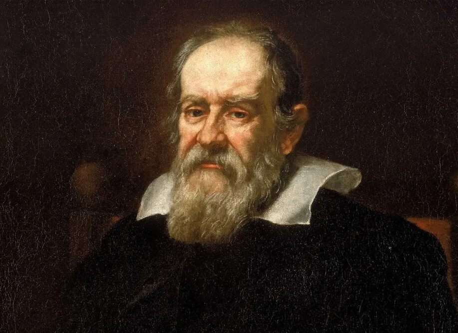A light-colored stone statue of Galileo Galilei in a niche, holding an object, depicting a historical figure to connect with.