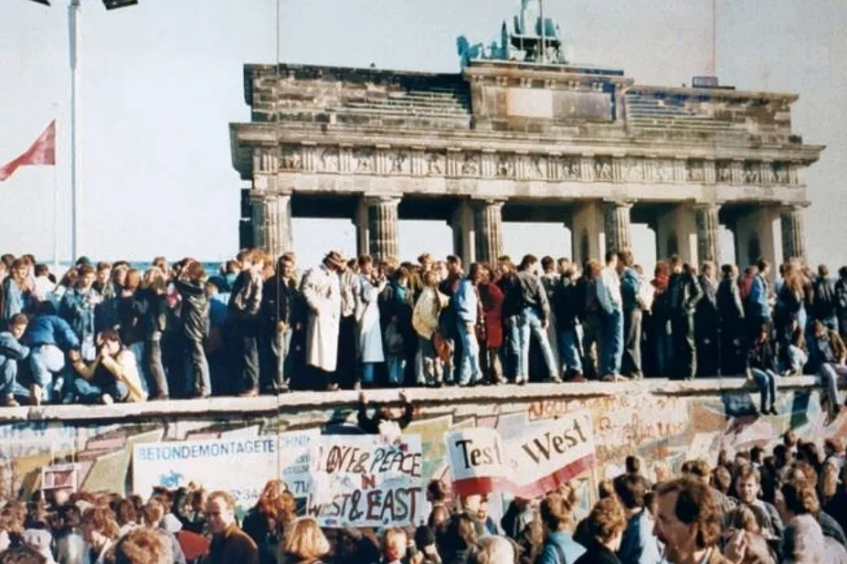Crowds celebrate the Fall of the Berlin Wall at the Brandenburg Gate, a pivotal European event in history.