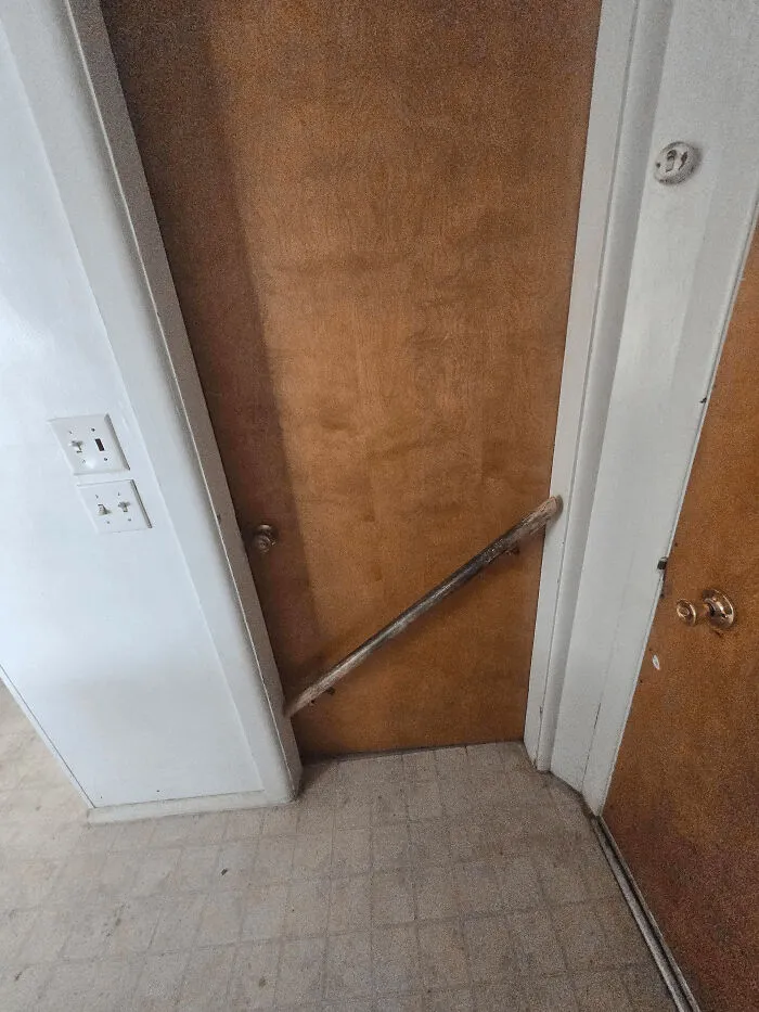 A wooden stick wedged between two doors, a clever solution to hold one door open or closed.