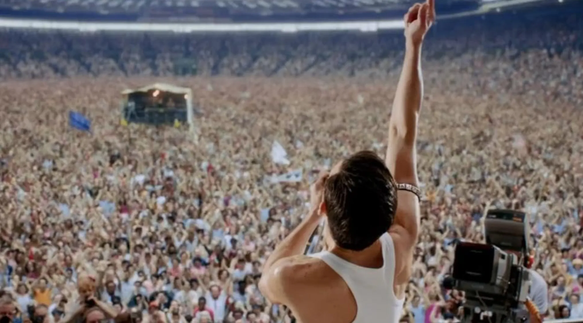 Freddie Mercury performing on stage at the Live Aid concert, a famous historic event portrayed in Bohemian Rhapsody.