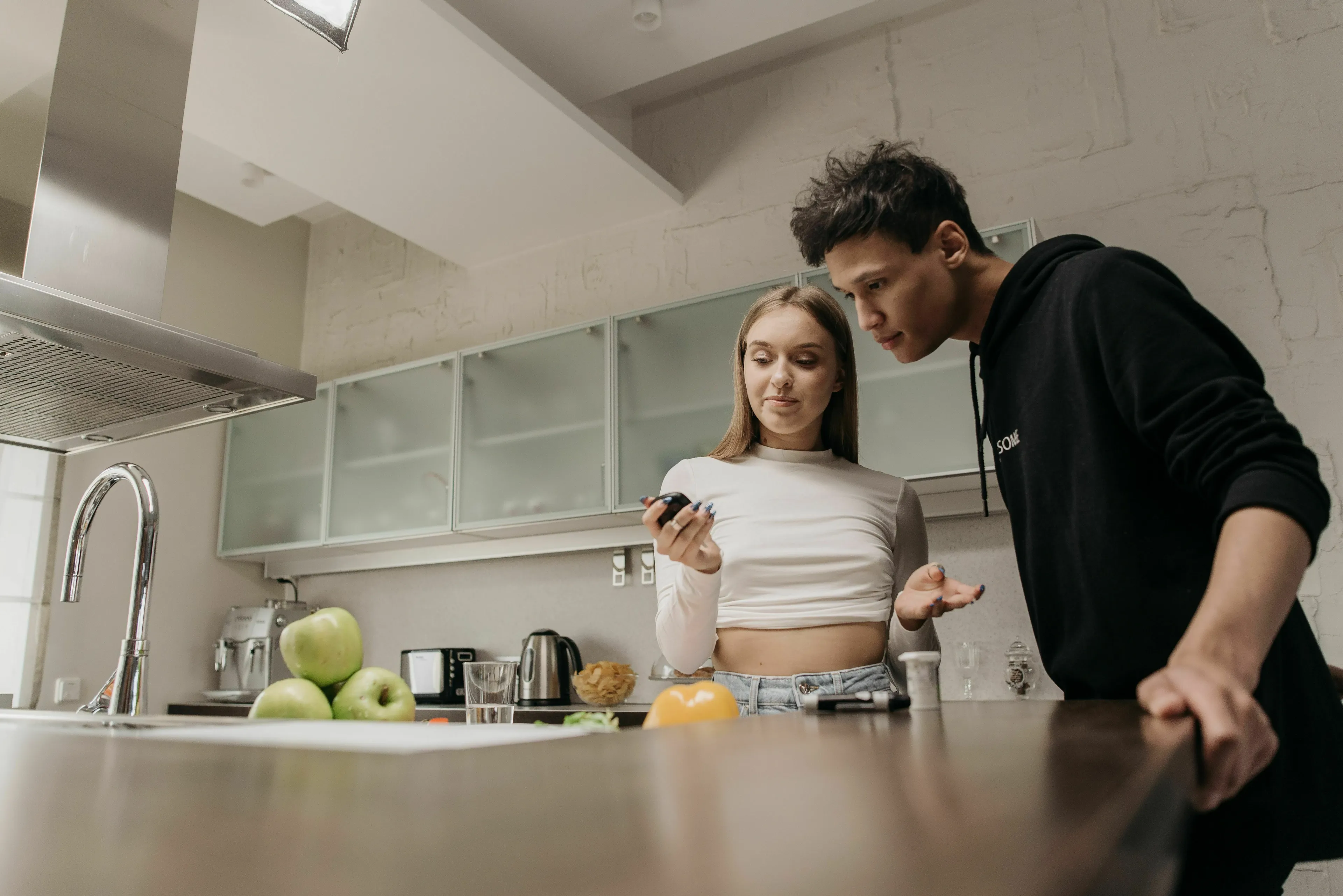 Basic Medical Knowledge Quiz: Two people in a kitchen, looking at a device used to regulate blood sugar levels, discussing hormones.