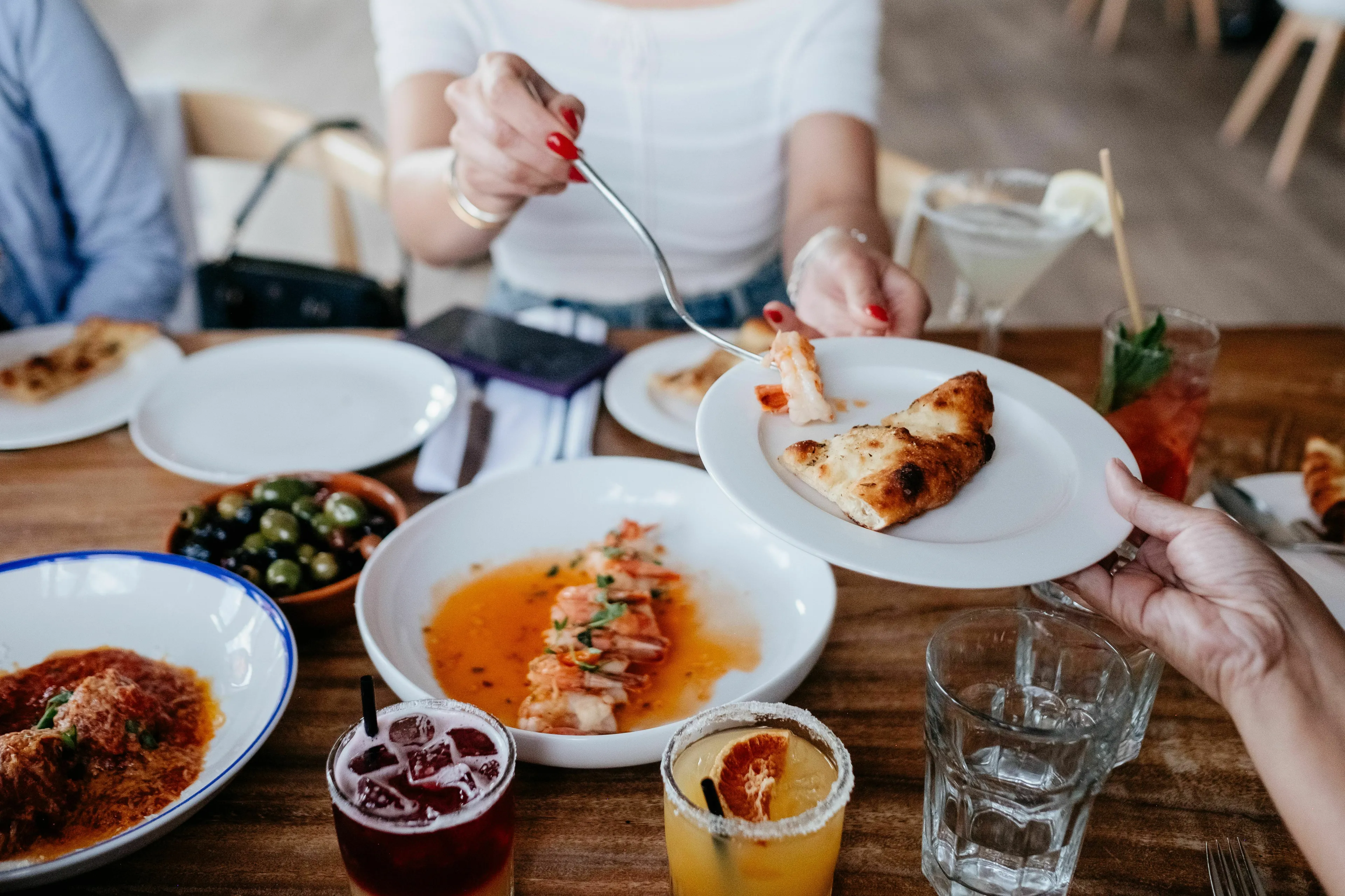 A person serves new food to a friend, showing a brave approach to trying different cuisines.