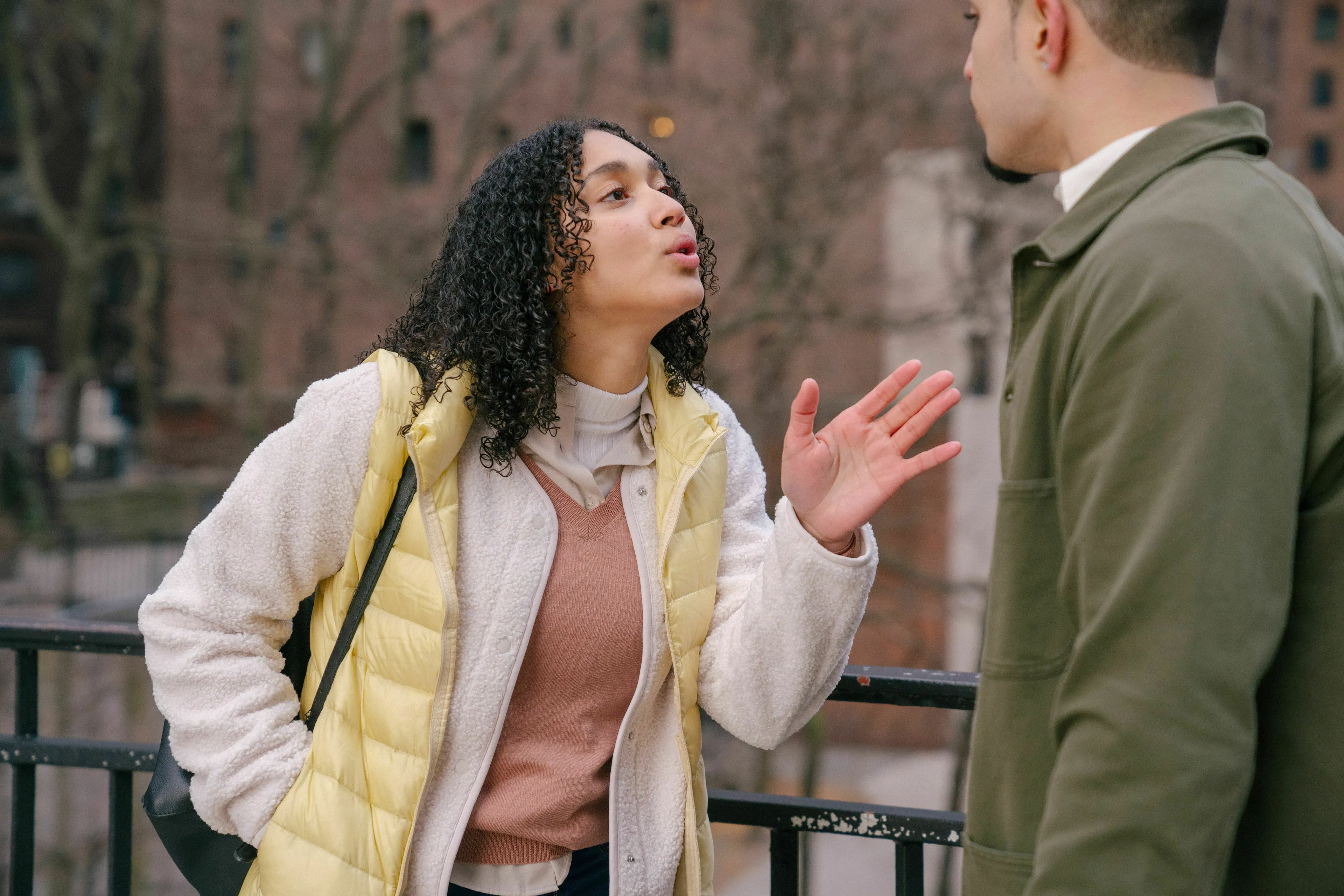 A woman arguing with a man, gesturing with her hand during a minor argument.