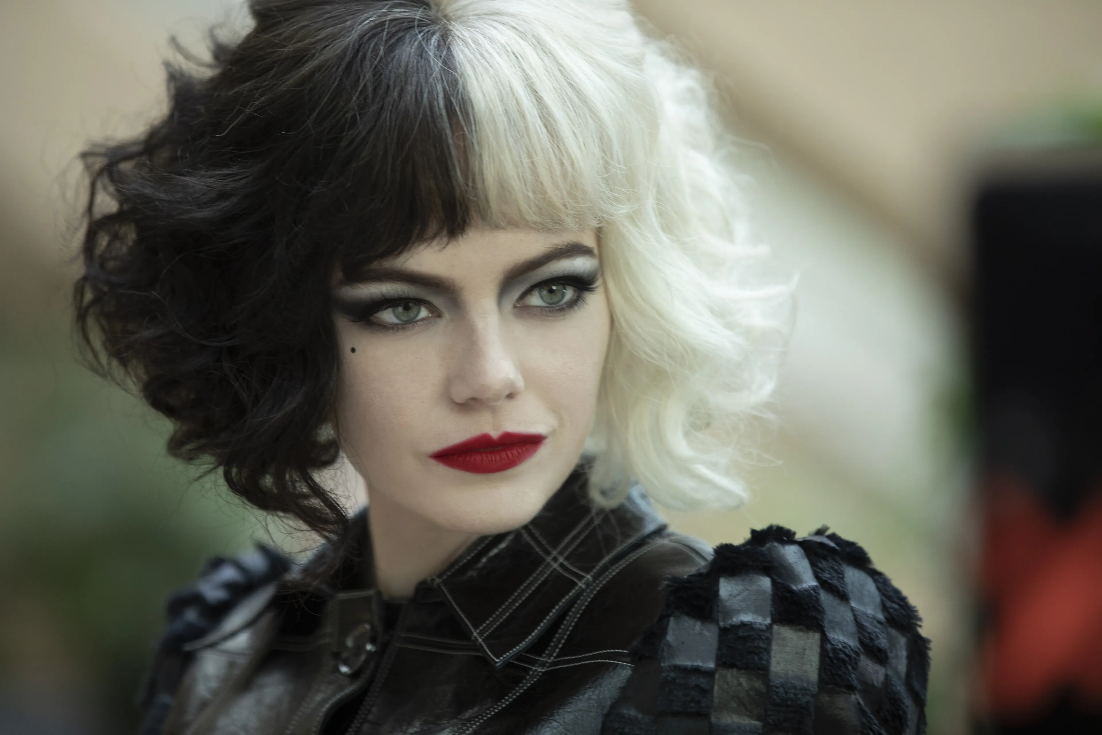 Cruella de Vil, a movie villain, with split black and white hair and red lipstick.