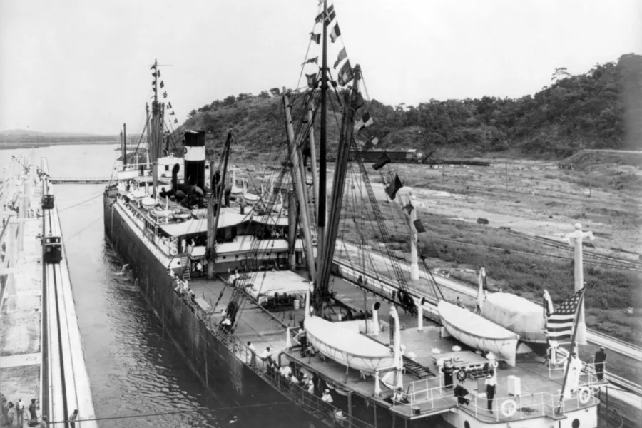 A large ship passing through the Panama Canal, showcasing the engineering marvel of the canal opening.