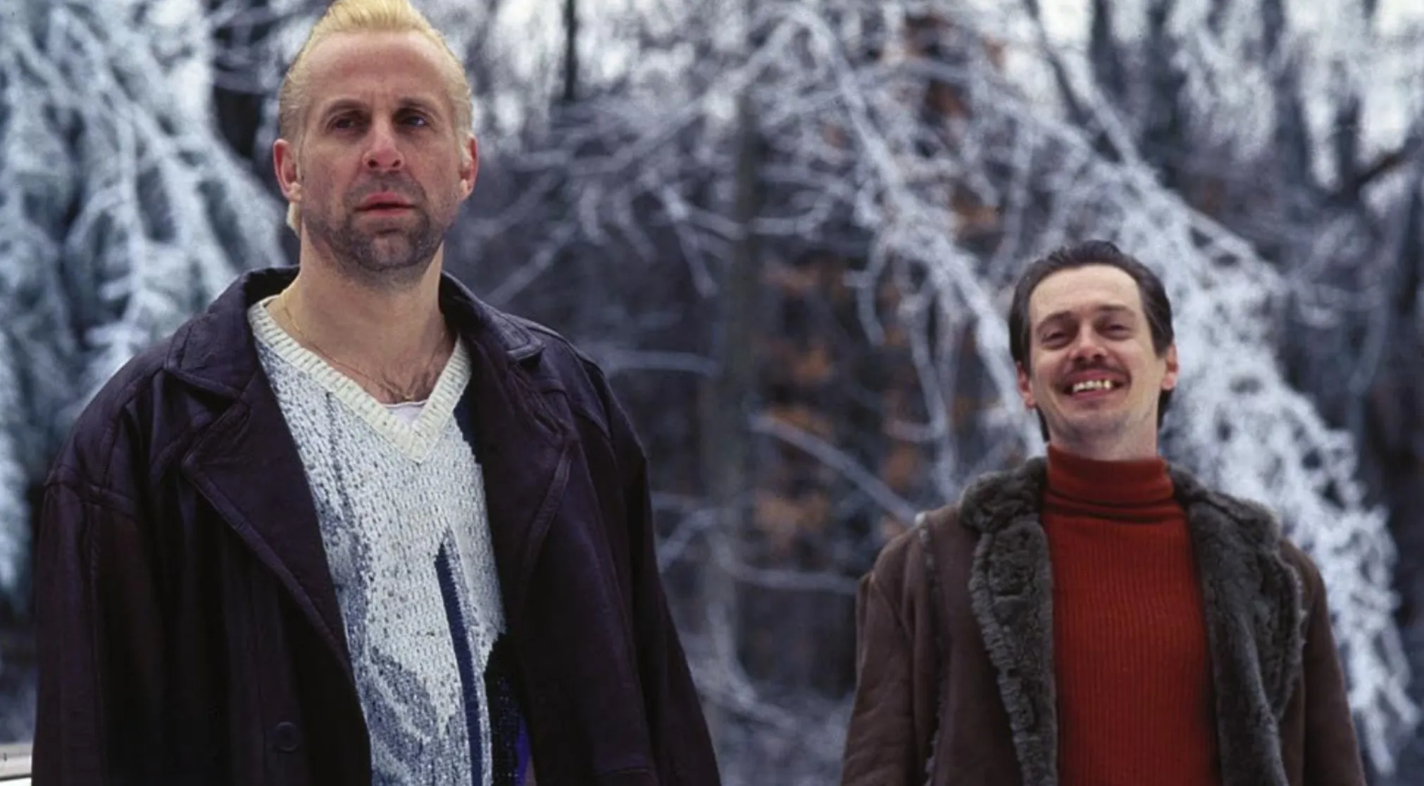 Two men in winter clothes against a snowy backdrop for 80s & 90s Movie Trivia. One serious, one smiling.