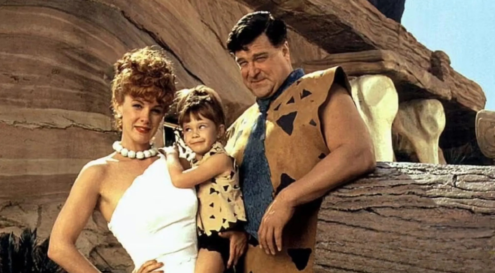 80s & 90s General Movie Trivia: A family of three, including a man, woman, and child, in stone-age attire.
