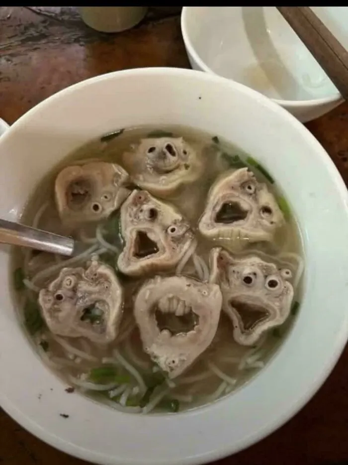 A bowl of soup with unusual face-like meat pieces showing questionable food combos.