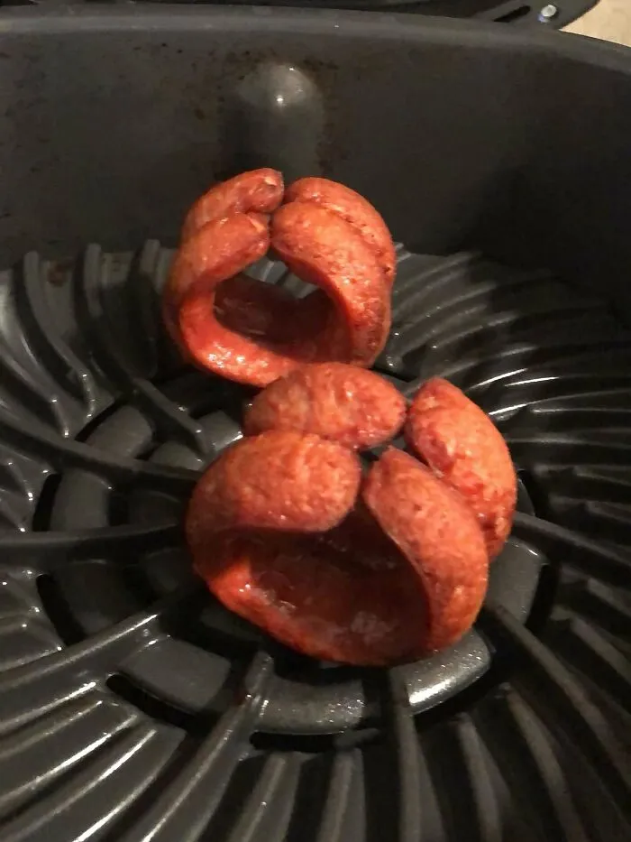 Deep-fried sliced sausages curled in an air fryer tray forming a questionable food combo.