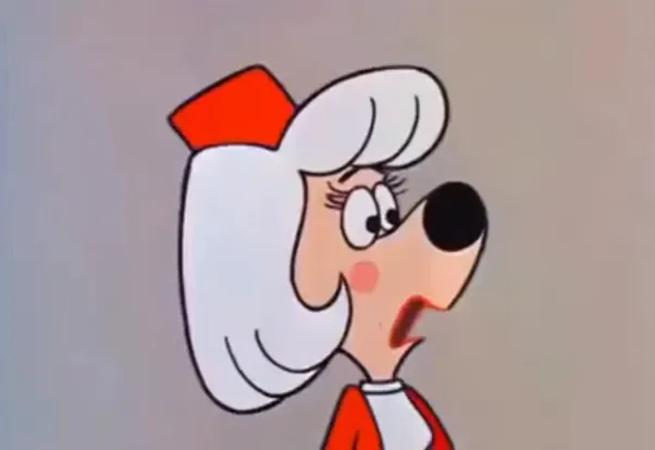 An animated female dog with white hair and a red hat, looking surprised. A character from Underdog.