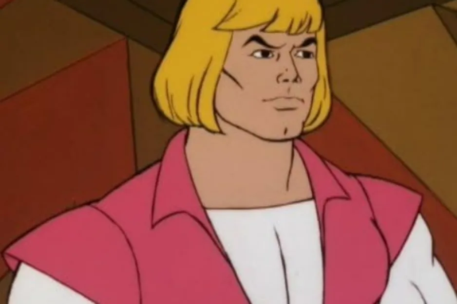 A close-up image of He-Man in a pink vest over a white shirt, with blond hair.