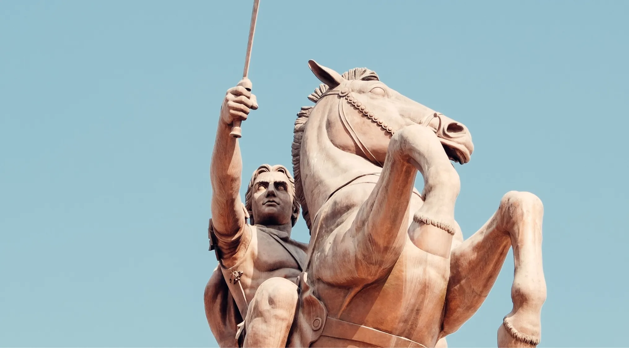 Literature: A historical horse-mounted warrior statue under a clear blue sky, evoking a hero or main character.