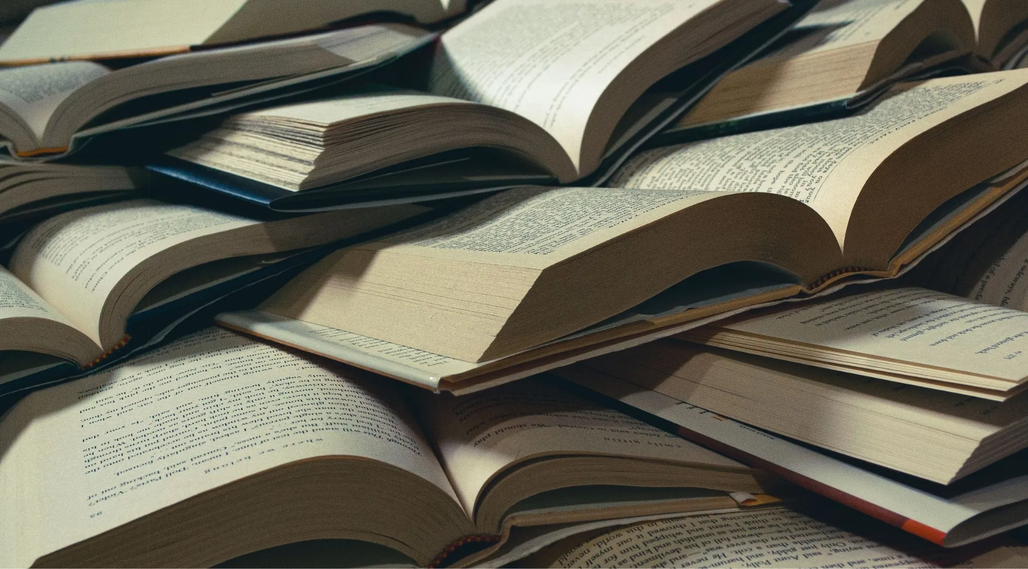 A pile of open books, pages visible, suggesting literature and the literary term for a warning or early hint.