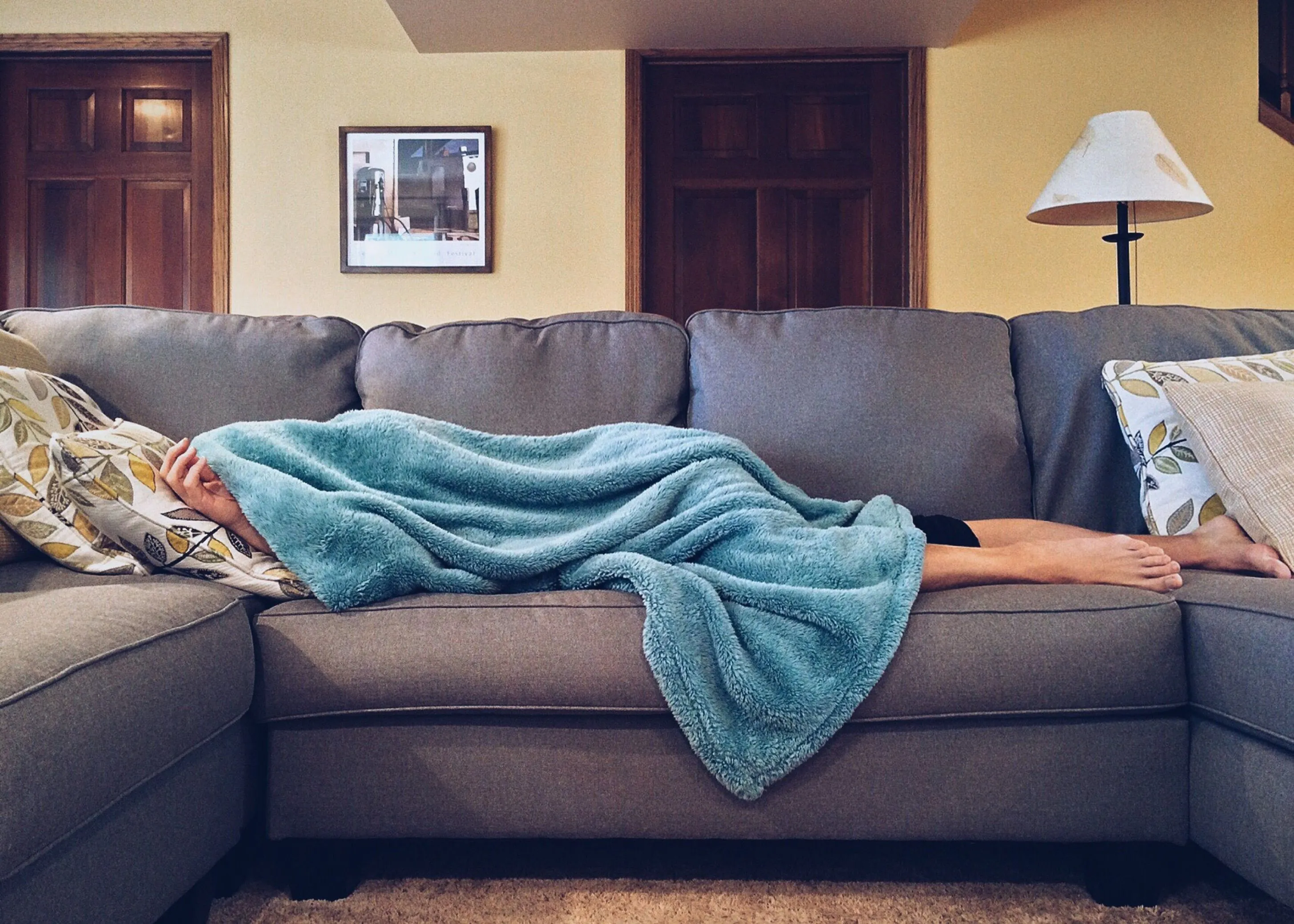 Someone sleeping under a blue blanket on my sofa, enjoying a Sunday afternoon.