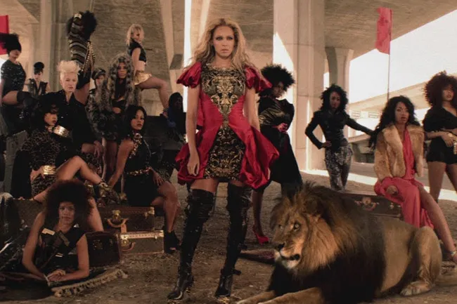 Beyoncé in a red dress with a lion, representing a mental state of running the world.