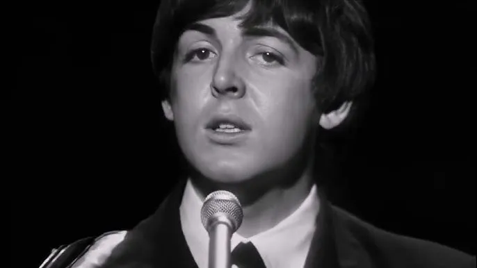 Paul McCartney singing into a microphone, a song that matches a current mental state of yesterday.
