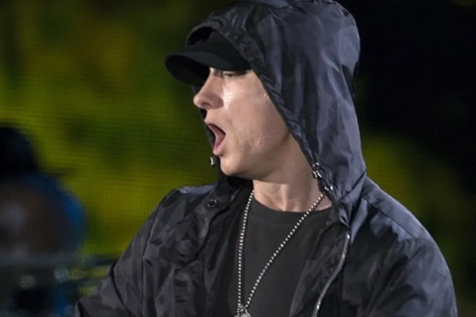 Rapper Eminem known for alter ego Slim Shady, wearing a hoodie and baseball cap.