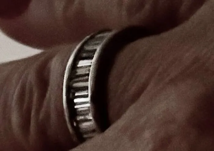 A close-up of a hand wearing a unique ring, experiencing something creepy.