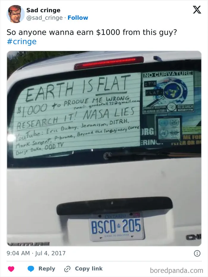 A rear view of a white car with a handwritten sign on the back window claiming Earth is flat, a cringy post.