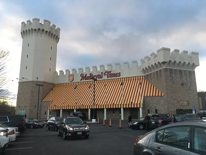 Medieval Times castle-themed dinner theater with striped awnings and parking lot