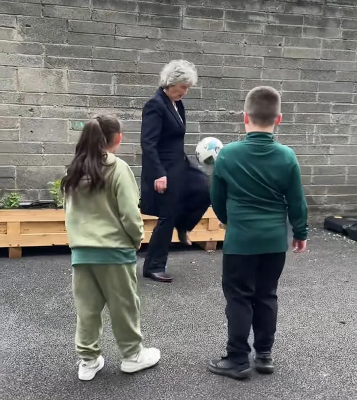 World leader playing soccer with children outdoors