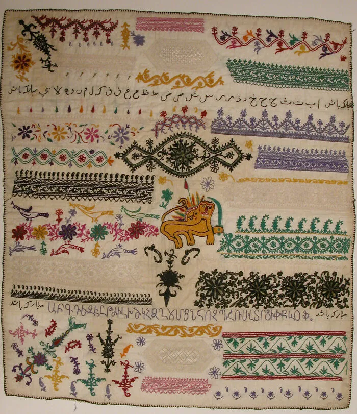 A finely detailed, vintage embroidered textile with various patterns and a central lion motif, an intact object.