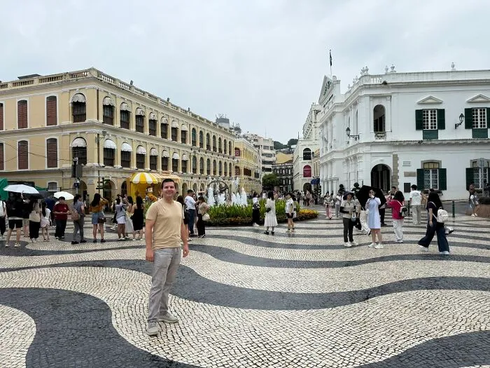 Traveler standing in a bustling square with historic buildings, showcasing unique places in China.