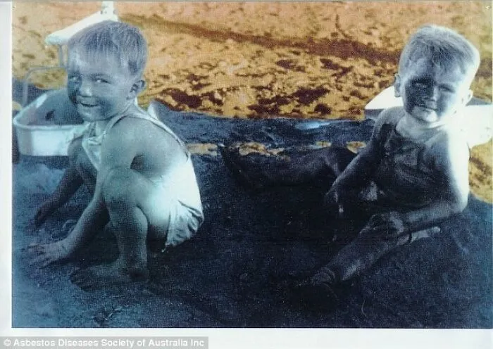 Los niños juegan en su área de juegos de amianto especialmente habilitada.