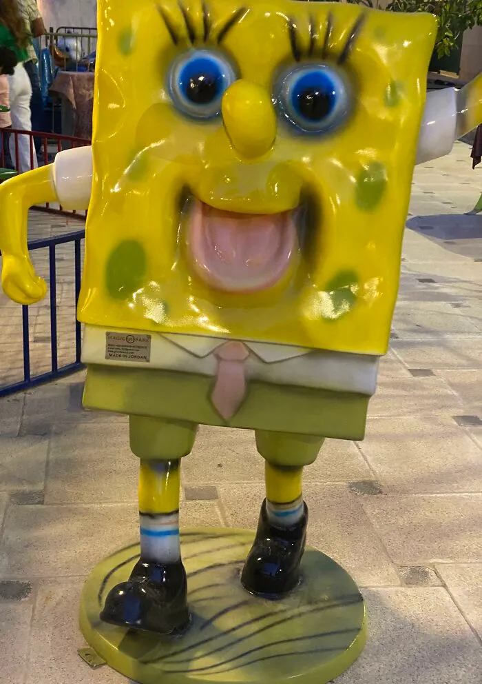Creepy SpongeBob statue with distorted face in outdoor area