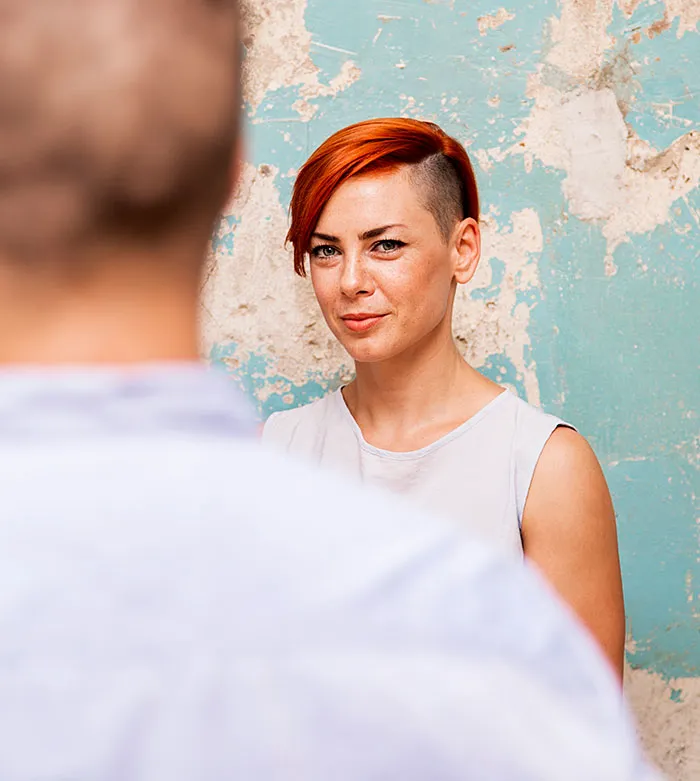 Woman with red hair engaging in polite conversation outdoors