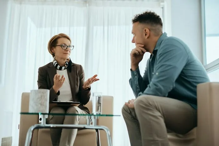 A therapist talking to a man, illustrating hints that a person is secretly very smart.