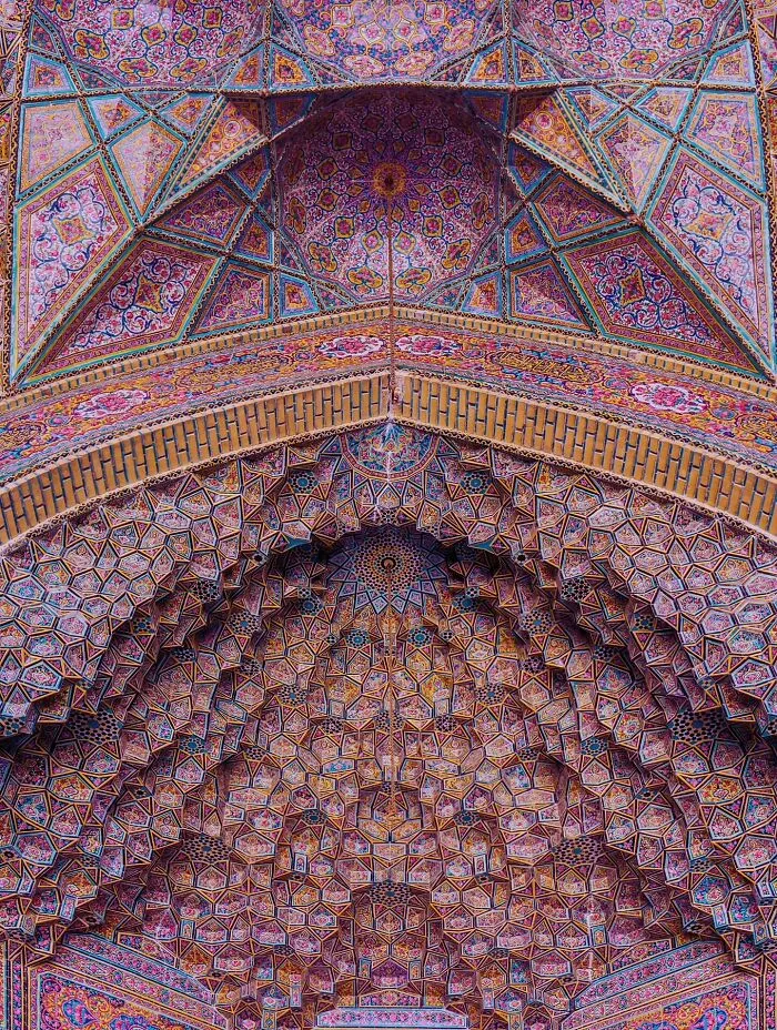 Detailed Persian geometric patterns on a mosque ceiling with vibrant hues