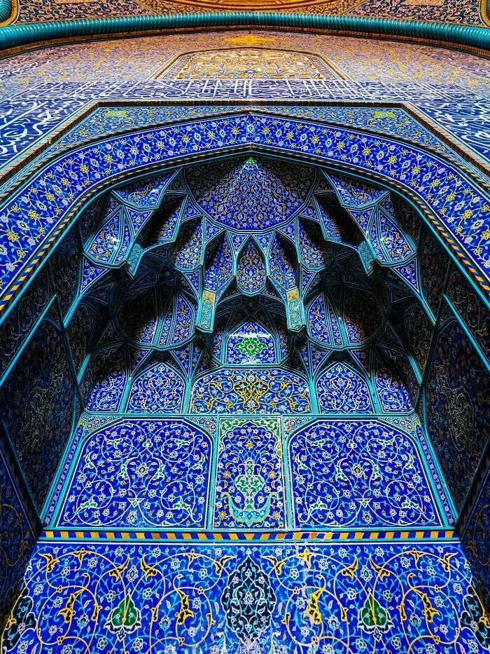 Detailed blue geometric Persian tilework covering mosque archway