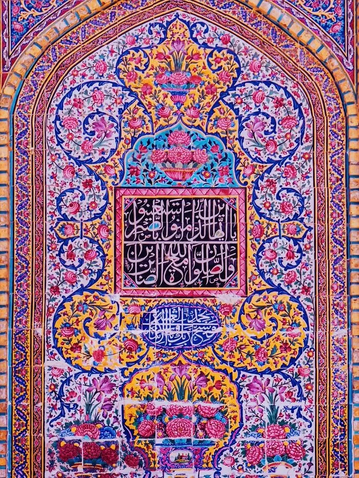 Colorful Persian floral and calligraphy tilework on arched wall panel