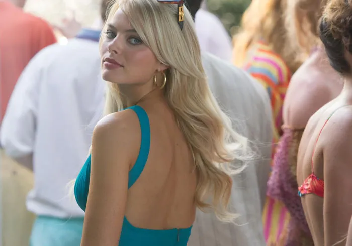 Blonde woman in blue dress at crowded event with cool facts theme