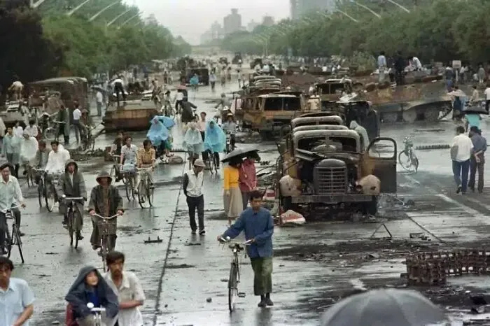 Personas caminan entre las consecuencias de la represión de las protestas de la Plaza de Tiananmen, 1989.