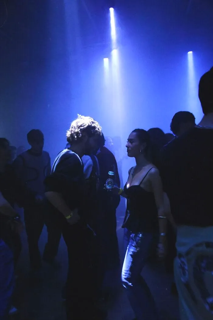 Friends dancing under blue lights at a party, capturing the vibrant energy of the photo trend.