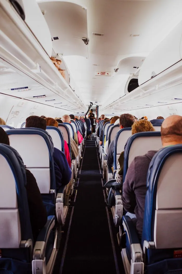 A wide shot of passengers on an airplane, illustrating a wild coincidence during travel.