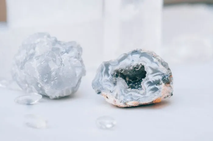 A pair of geodes, one open revealing crystals, on a white surface, representing wild coincidences.